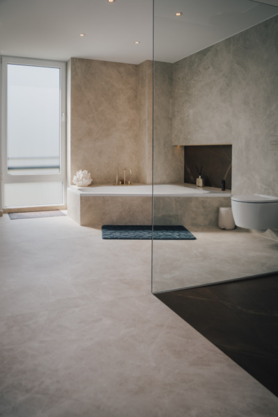 fugenloses-badezimmer-grossformat-keramik-fliesen-laminam-diamond-cream.webp Badewanne Naturstein Modernes Badezimmer Wiebe